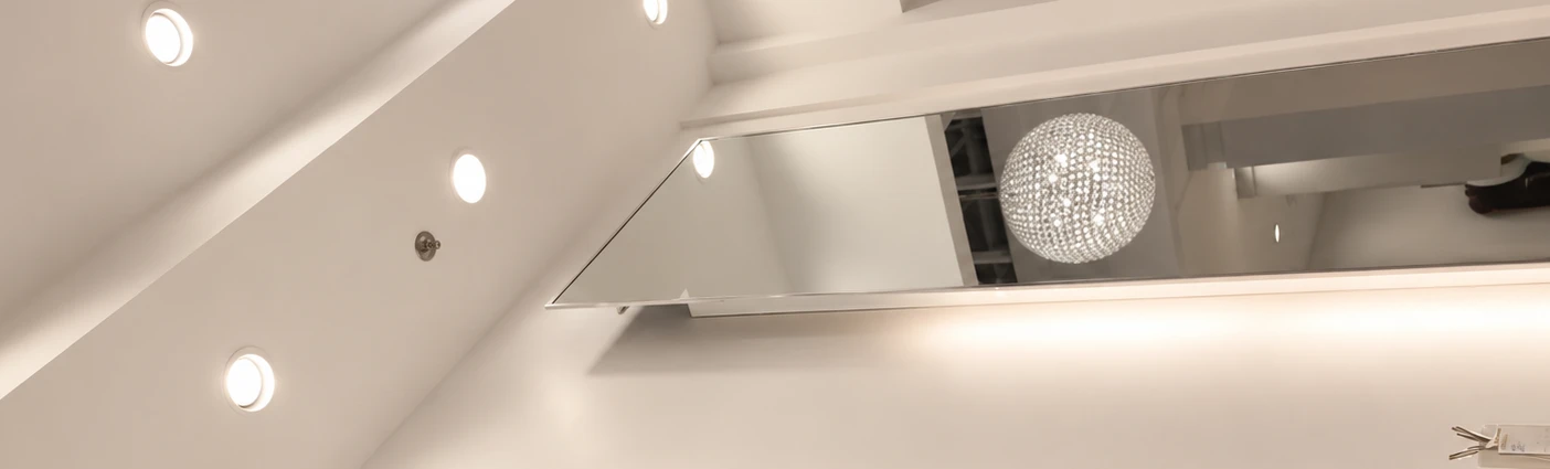 Lit ceiling, mirror and crystal chandelier in the Forever Young hair studio